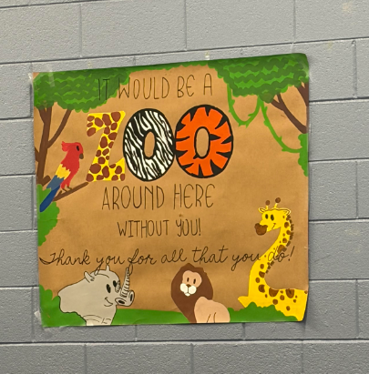 Poster on a brick wall. It says, "It would be a zoo around here without you!" Animals include a parrot, rhino, lion, giraffe, and zebra.
