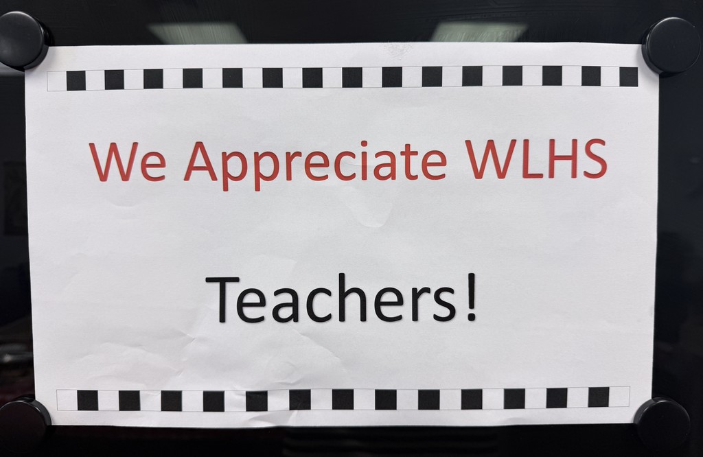 A white paper with black text on a black background reads, "We Appreciate WLHS Teachers!" Bordered by a film strip pattern.