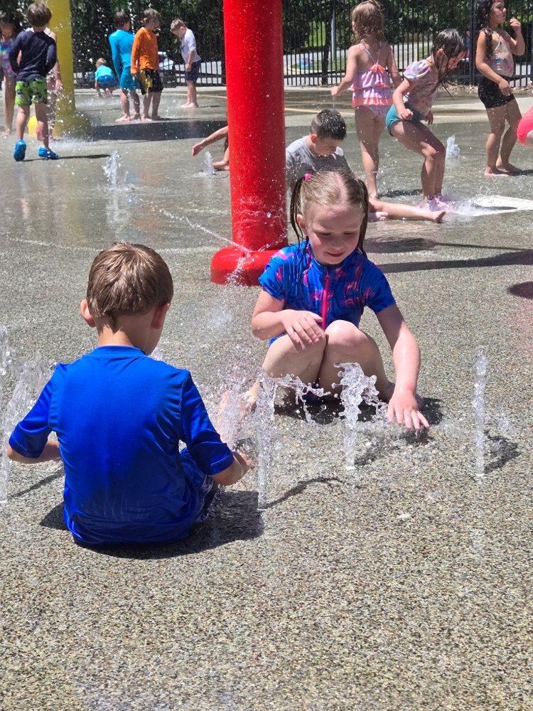 2 kids at a splash pad playing