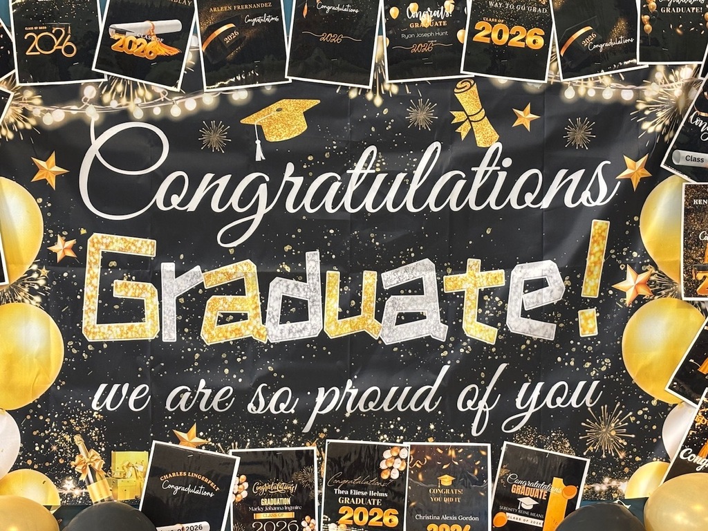 A celebration backdrop displays "Congratulations Graduate!" in white, gold, and black with a graduation cap and balloons.