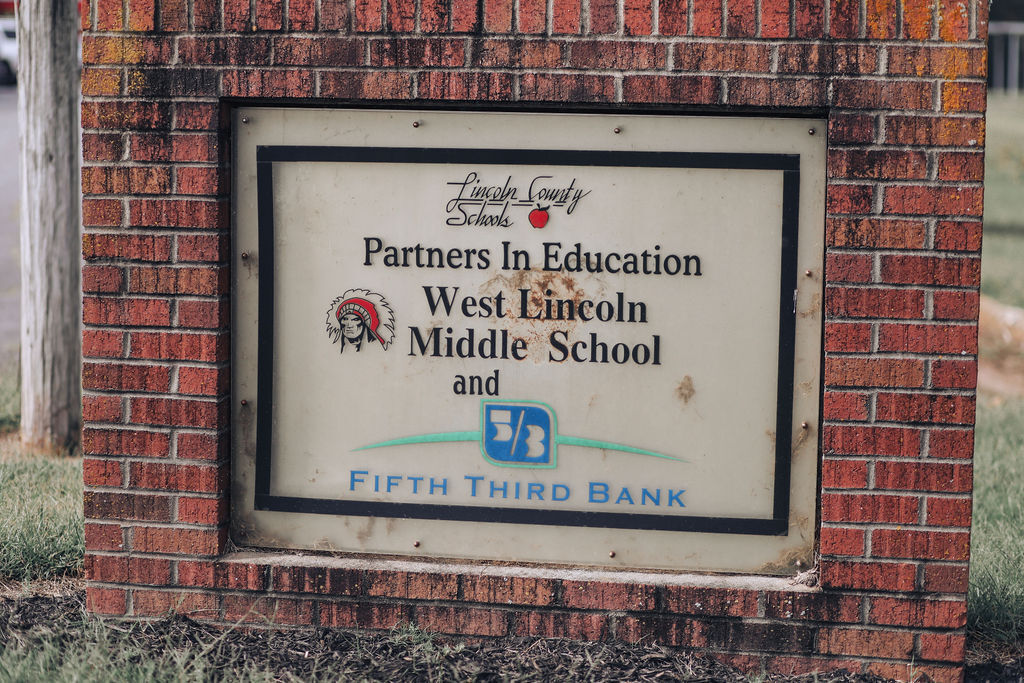 A brick sign displaying "Partners In Education West Lincoln Middle School and Fifth Third Bank" with logos.