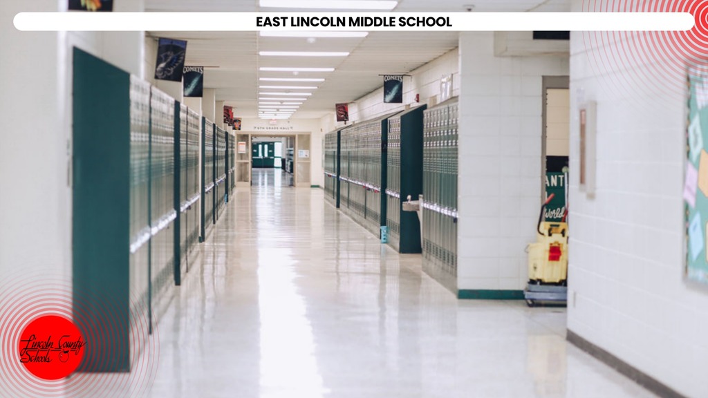 Empty hallway in a school. Green lockers on both sides. Bright white floor. White walls. Two red signs on the bottom left.