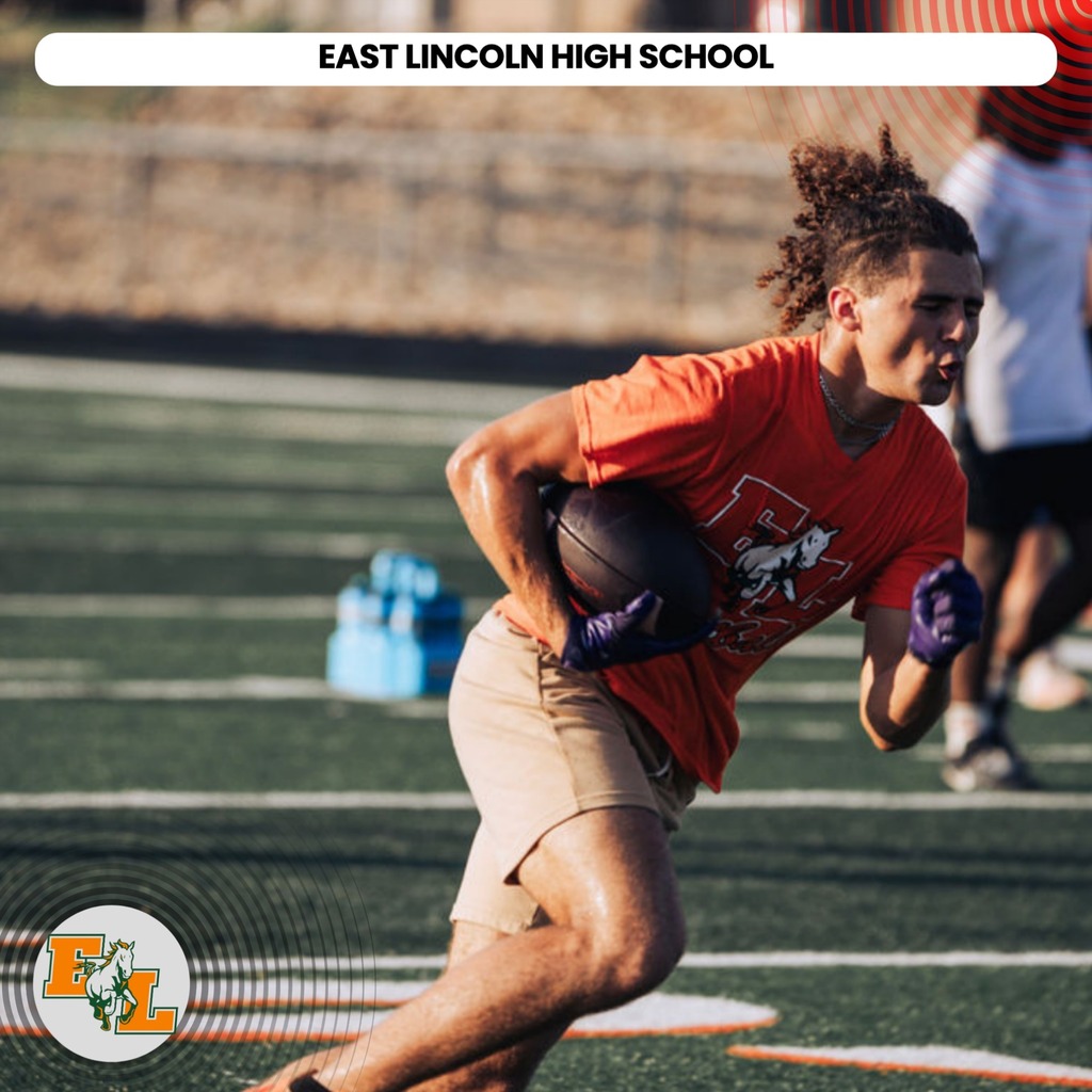 A football player runs with a ball on a field. The player wears a red shirt, tan shorts, and gloves.