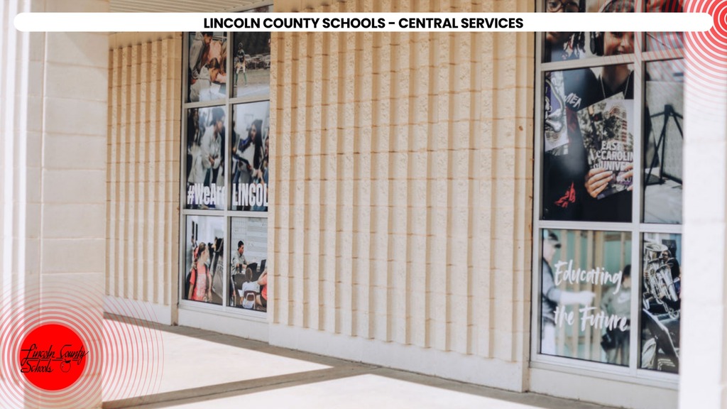 Exterior of Lincoln County Schools Central Services building with horizontal panels and glass windows displaying various images.