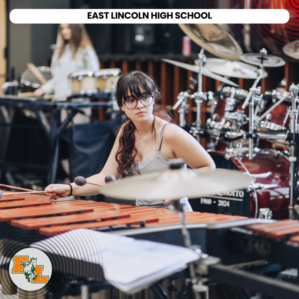 A student at East Lincoln High School plays a xylophone with a female drummer in the background.