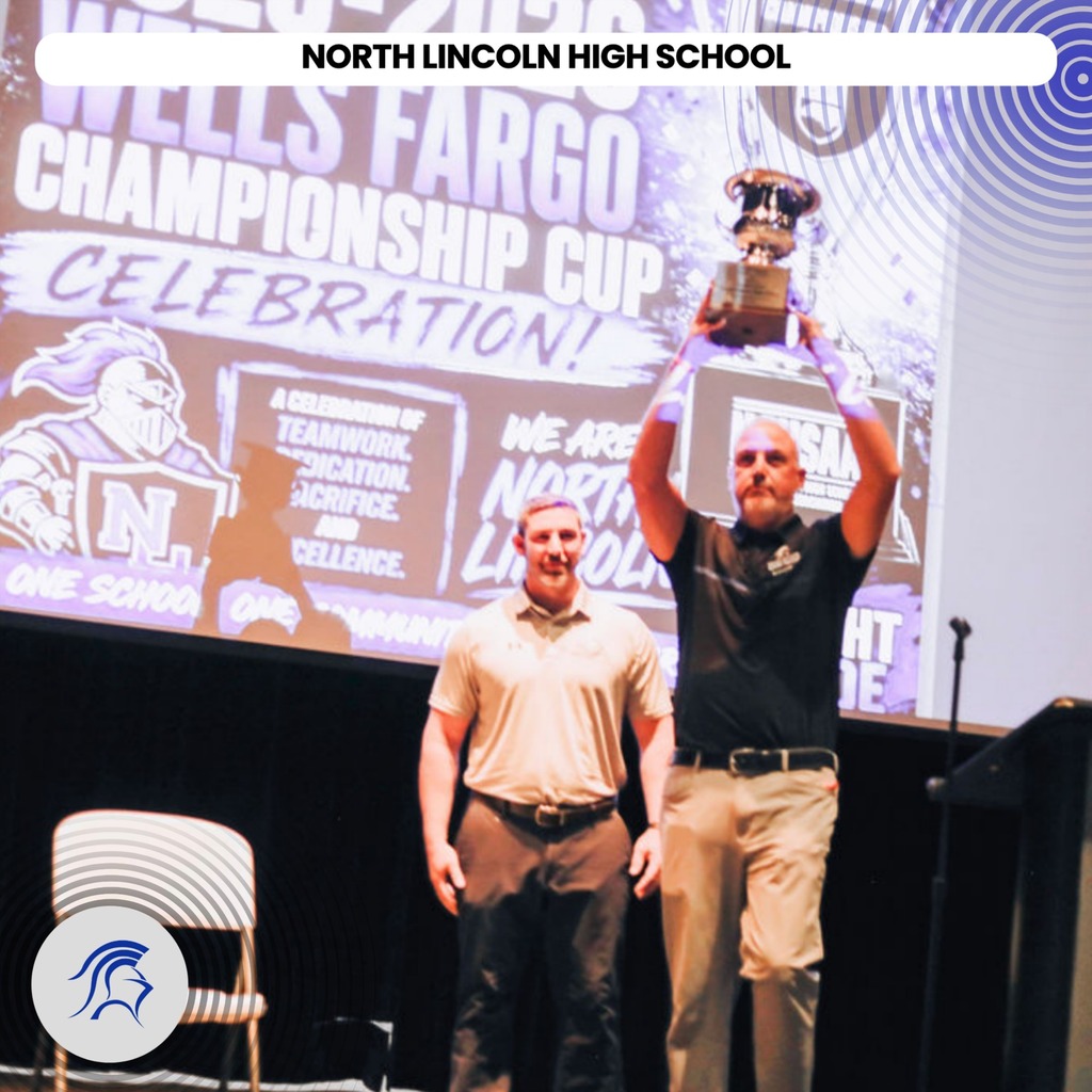 Two men on stage with a trophy, one holding a cup. Behind them, a large screen reads "North Lincoln High School".