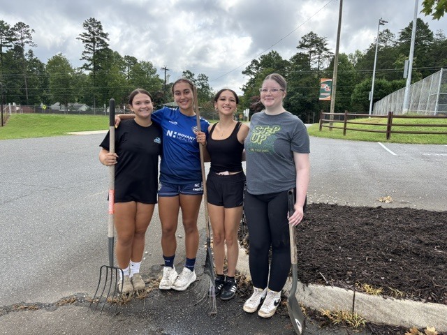 Beta and Garden Club students spreading mulch and planting flowers on campus.