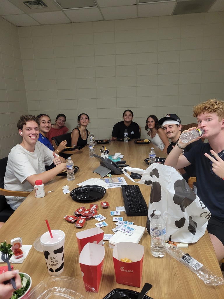 Beta and Garden Club students eating lunch after spreading mulch and planting flowers on campus.