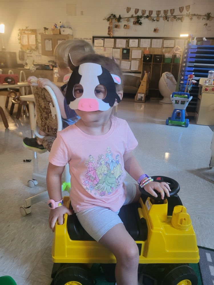 A sweet pre-k student poses with a cow mask