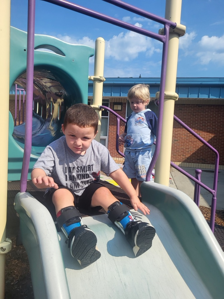 Two pre-k students use the playground