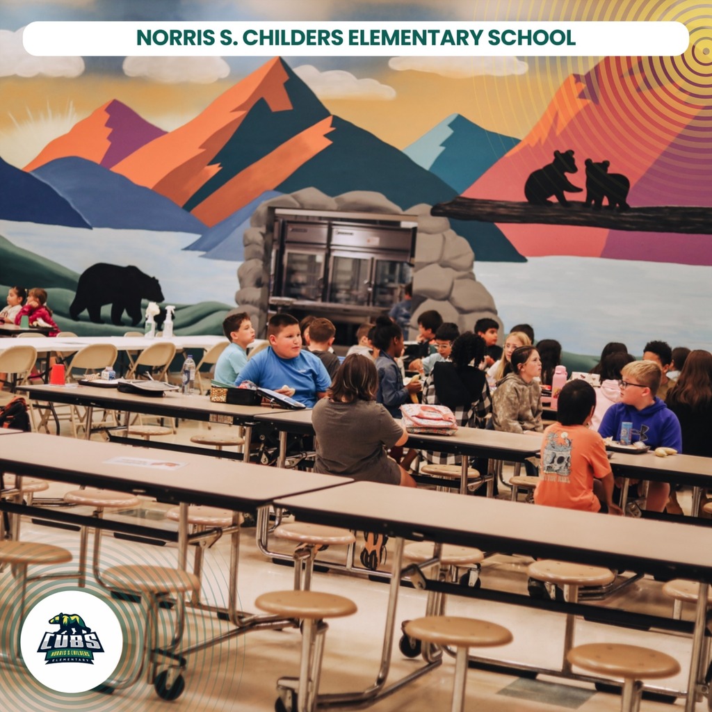 A cafeteria with students seated at tables. A mural of mountains and bears is on the wall.