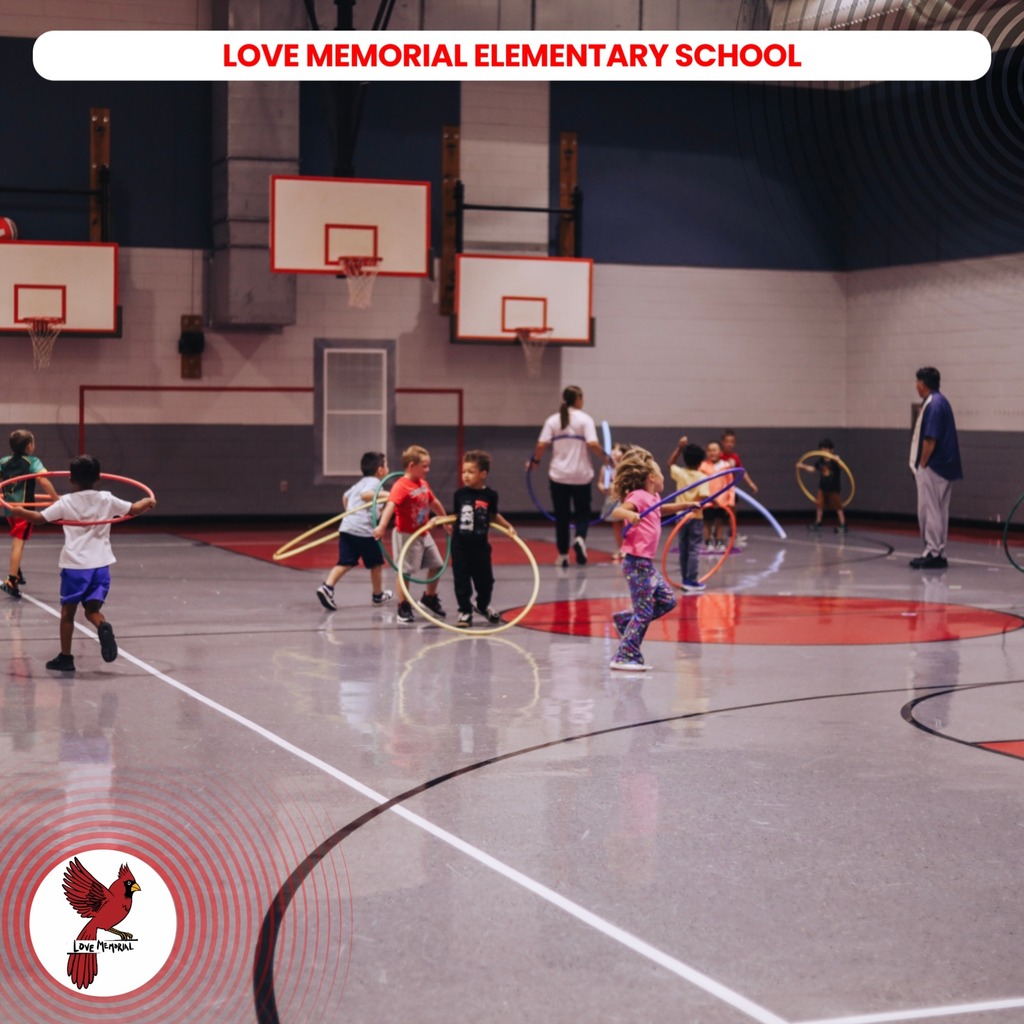 Kids playing with hula hoops in a gym. Two basketball hoops are in the background.