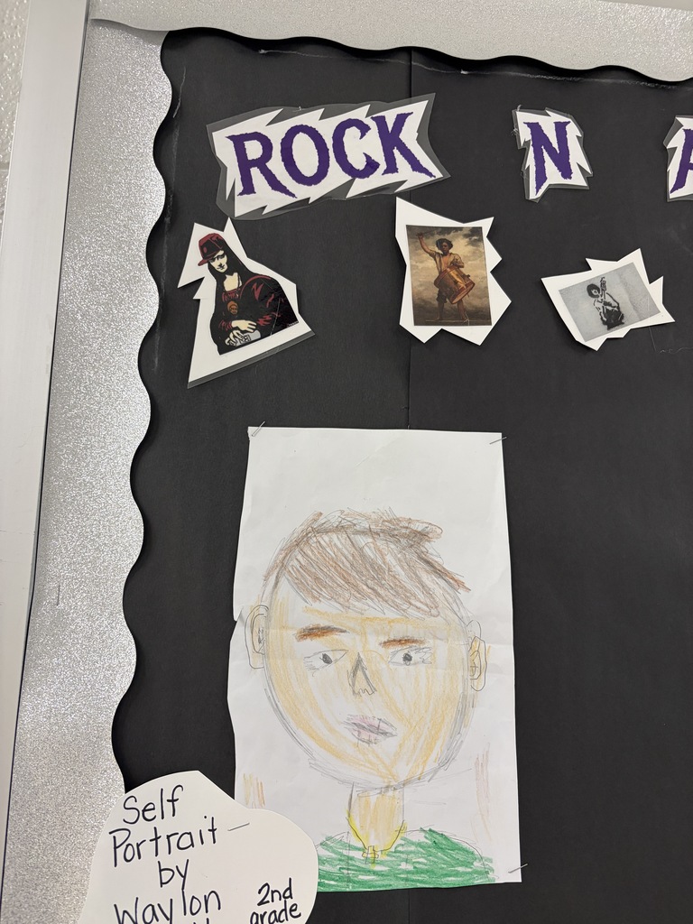A blackboard displays a drawn self-portrait of a person and the text "Self Portrait by Waylon 2nd grade".