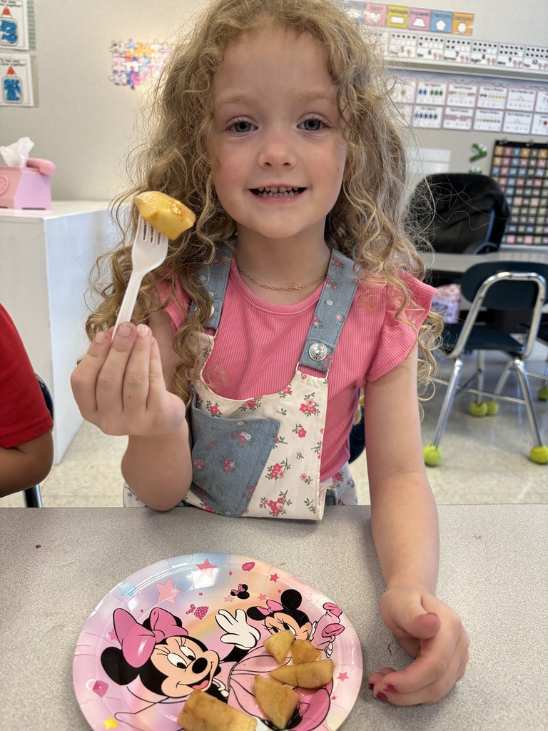 Student tasting cinnamon apples that she made with her classmates.