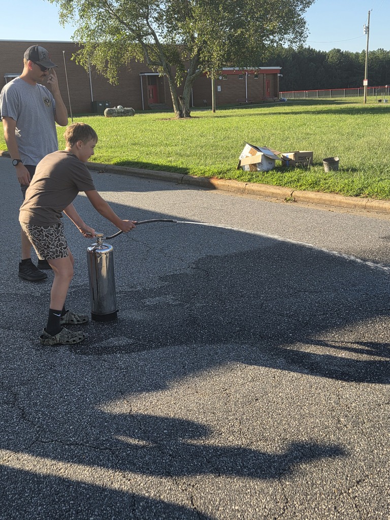 A young boy holding a metal object and a man beside him. They are near a building.