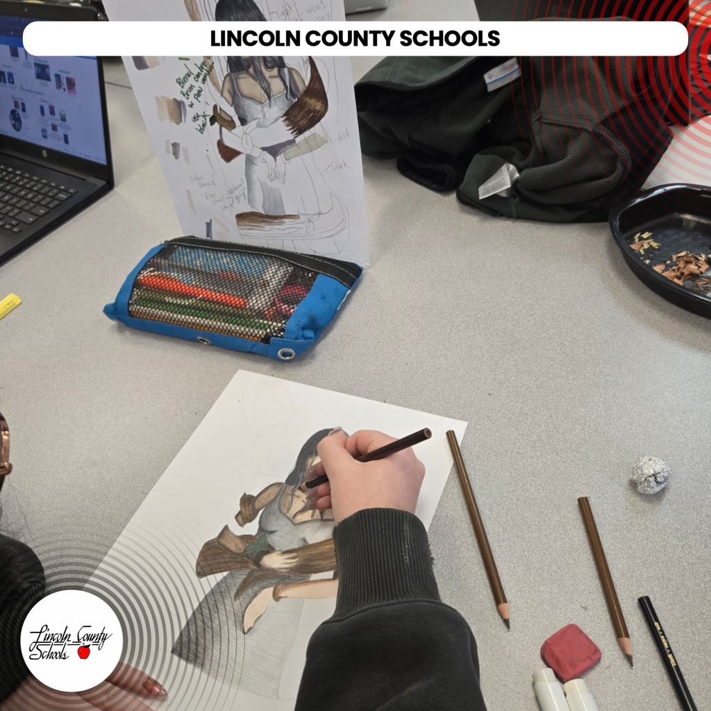 A student at Lincoln County Schools uses a pencil to draw on paper. Other materials like colored pencils and erasers are on the table.