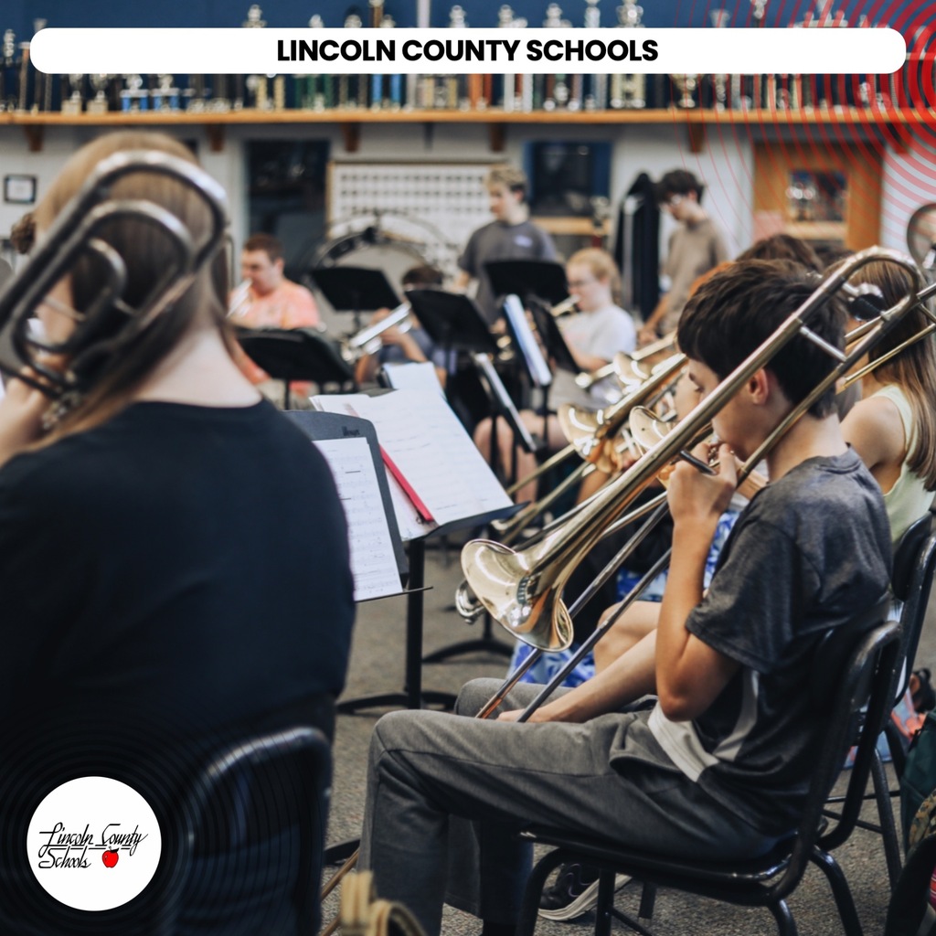 A group of students in a room, with musical instruments like trombones, sit in chairs. A text overlay reads "LINCOLN COUNTY SCHOOLS".