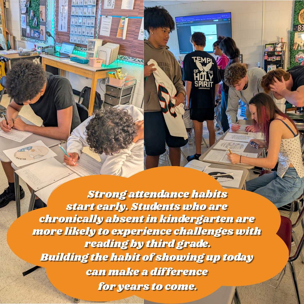 Three students sit at tables in a classroom. One student writes in a notebook. A teacher helps another student.