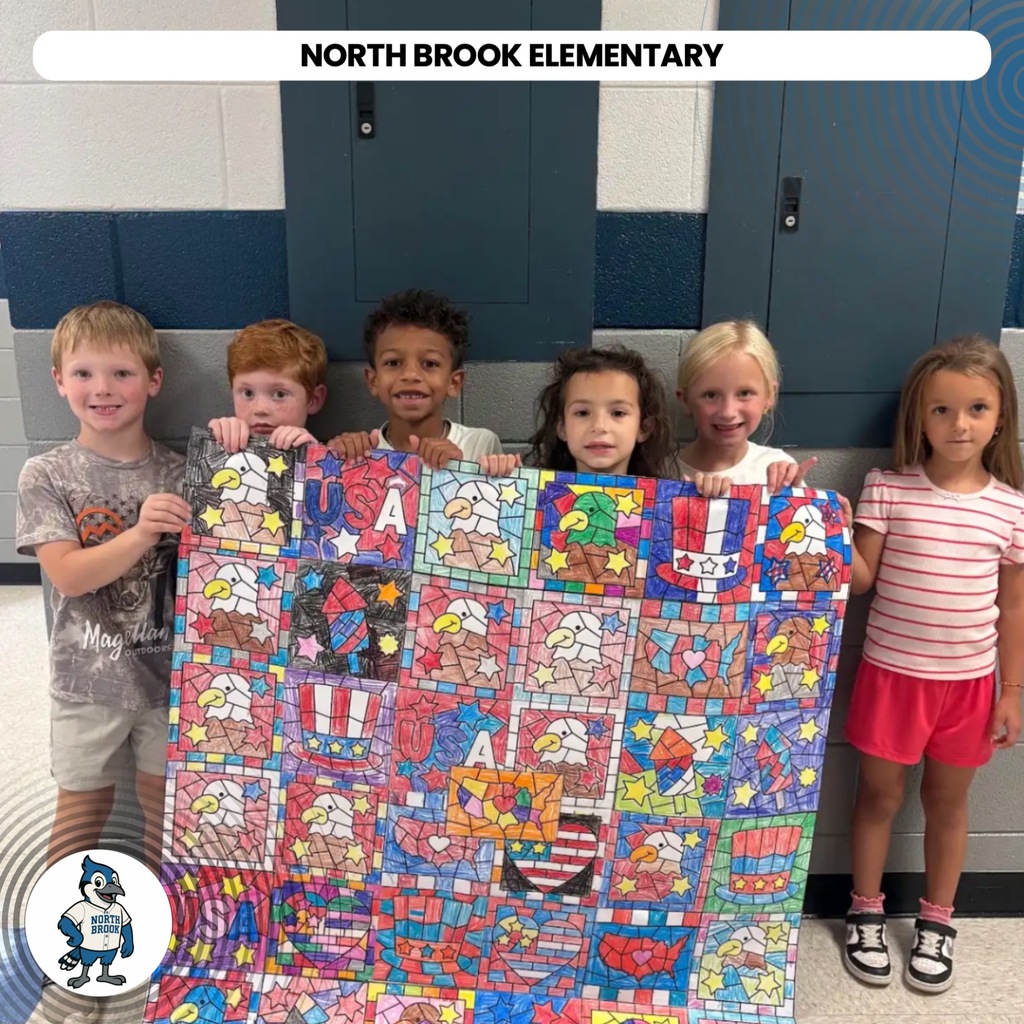 Five children stand behind a colorful quilt, smiling, inside a school hallway. A logo is in the bottom left.
