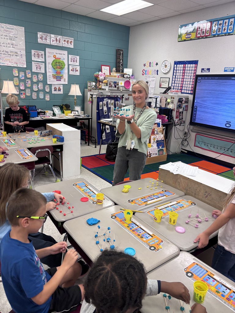 Miss McMurray, student teacher, modeling 3D shapes for students.