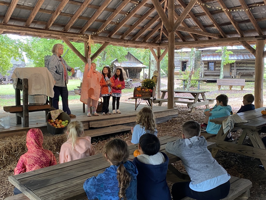 Students learning how to make apple cider on their field trip to Hart Square