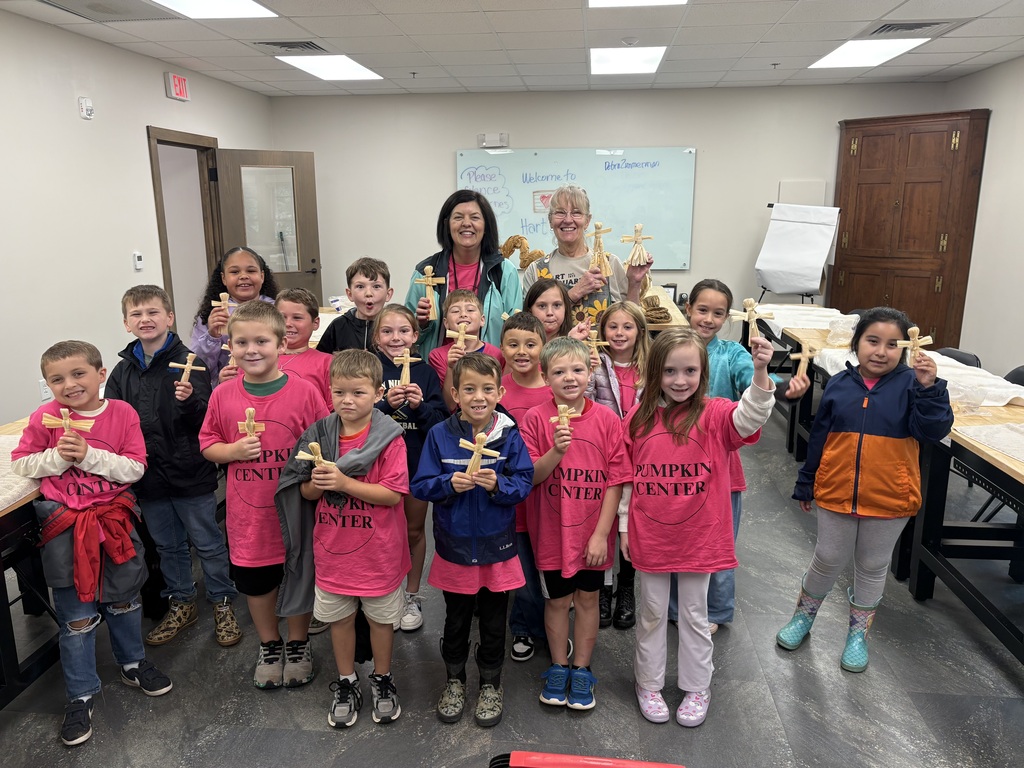 Students making corn husk dolls on their field trip to Hart Square