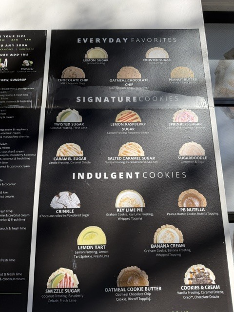Black menu with a list of cookies. Includes Everyday Favorites, Signature Cookies, Indulgent Cookies, and cookies with various flavors.