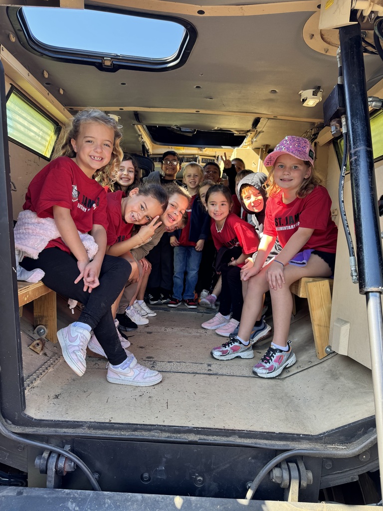 Children in matching shirts and sneakers sit inside a vehicle. A few are seated on benches.