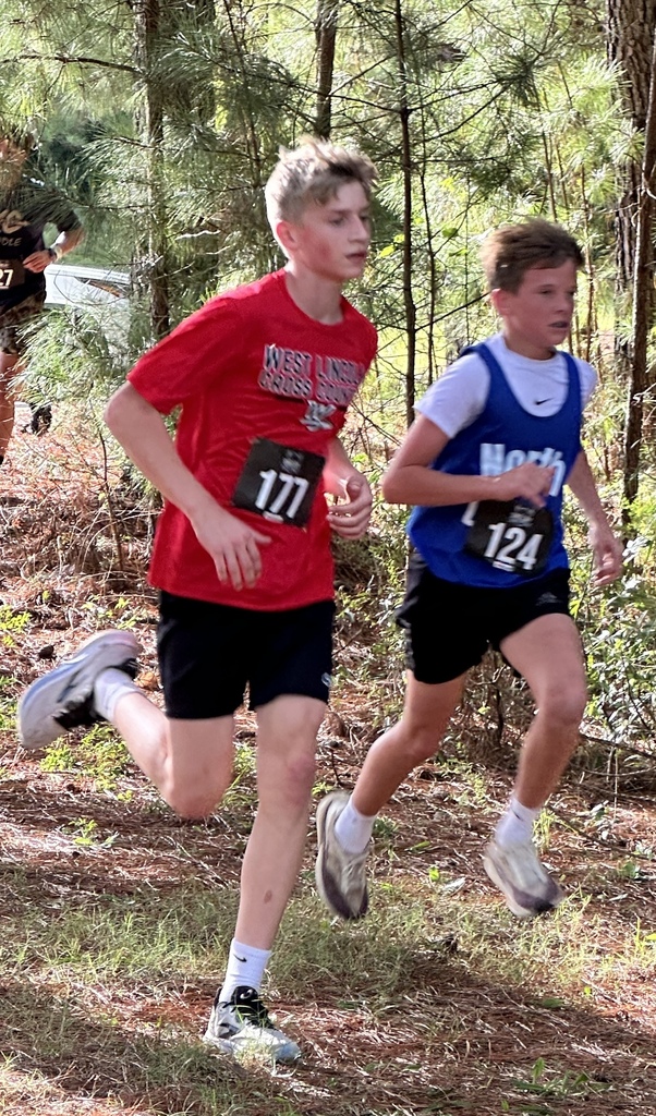 Two young athletes running in a trail race. One wears a red shirt with the number 177.