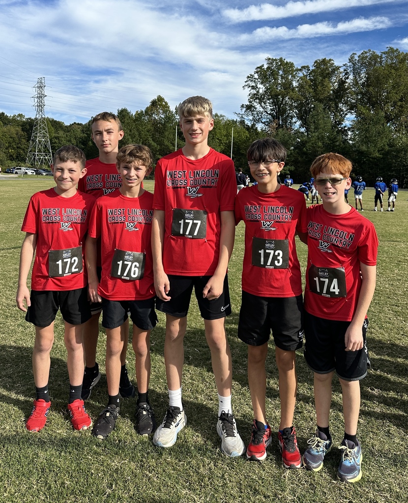 Six boys wearing red shirts with numbers 172, 176, 177, 173, 174 stand together in a grassy field.