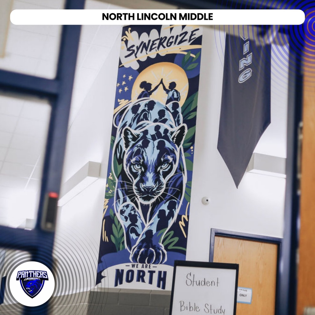 A blue banner with a tiger in front of a full moon hangs in a school hallway.