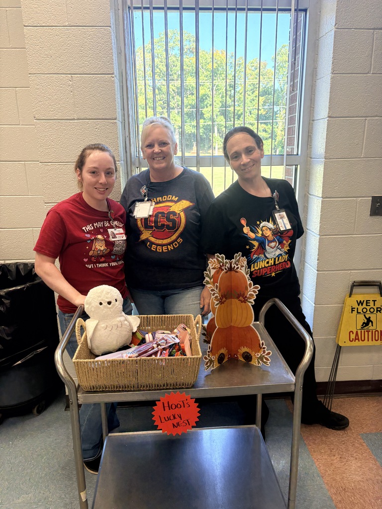 Four adults stand behind a table with two baskets of toys and a sign that reads "Holiday Treats".