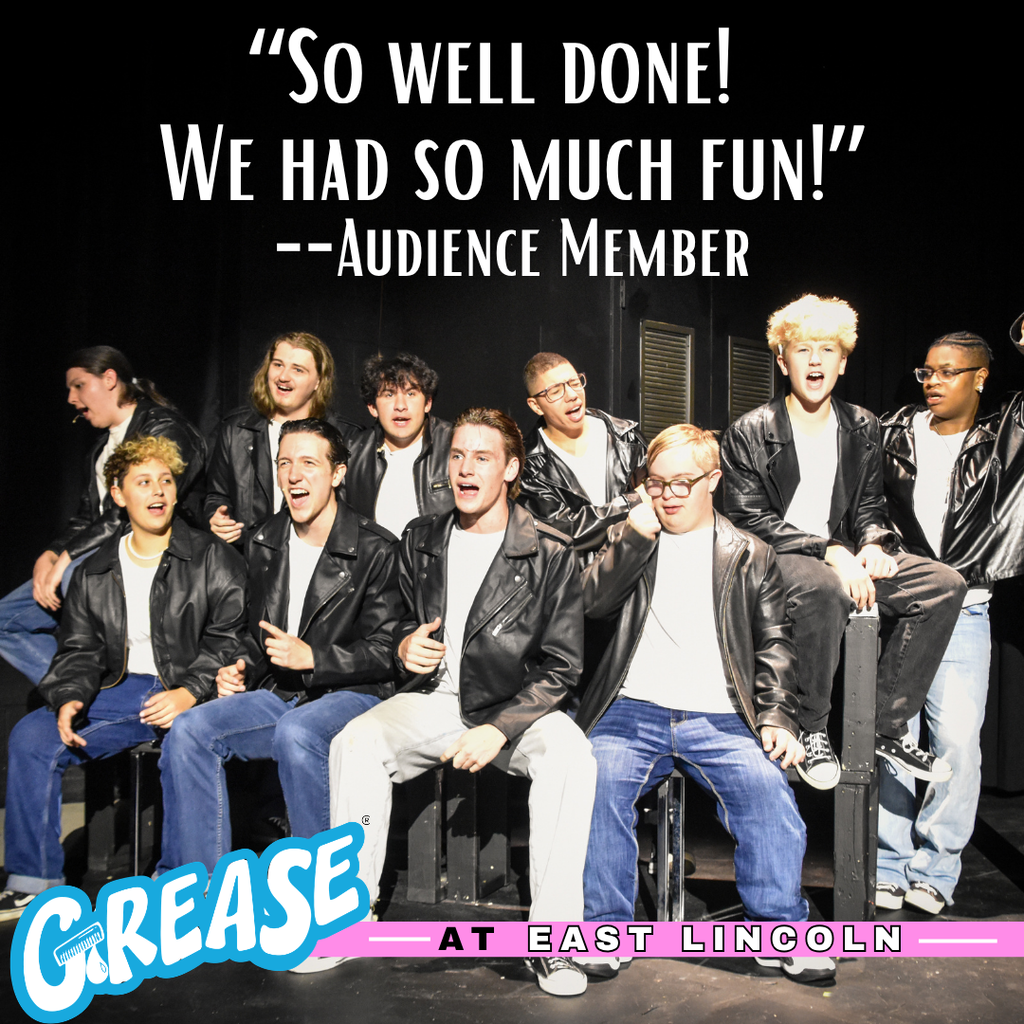 Group of young people in leather jackets and jeans sitting on chairs on stage, smiling for a photo.