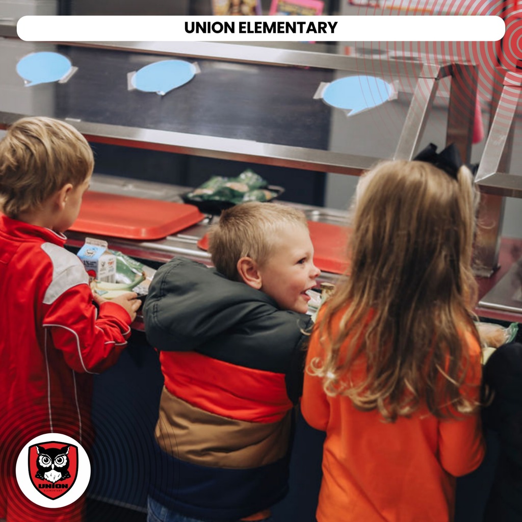 Three children, two boys and a girl, at a cafeteria counter. The boy on the left wears a red jacket.