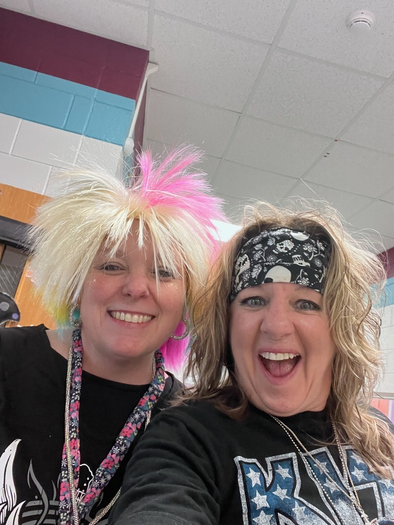 Two women with blonde hair, one with pink and one with a bandana, smiling for a selfie.