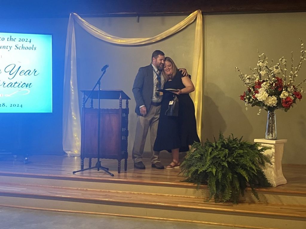 man hugging a woman after receiving a reward at celebration of the year