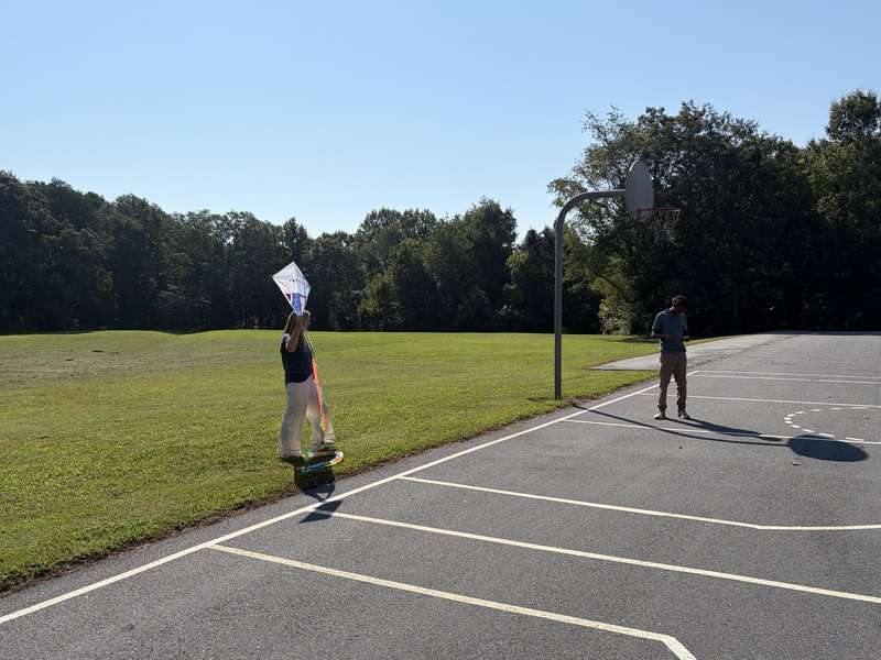 Student and teacher outside flying a kite