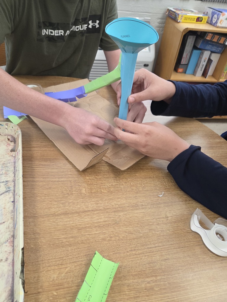 Students building support beams out of paper.