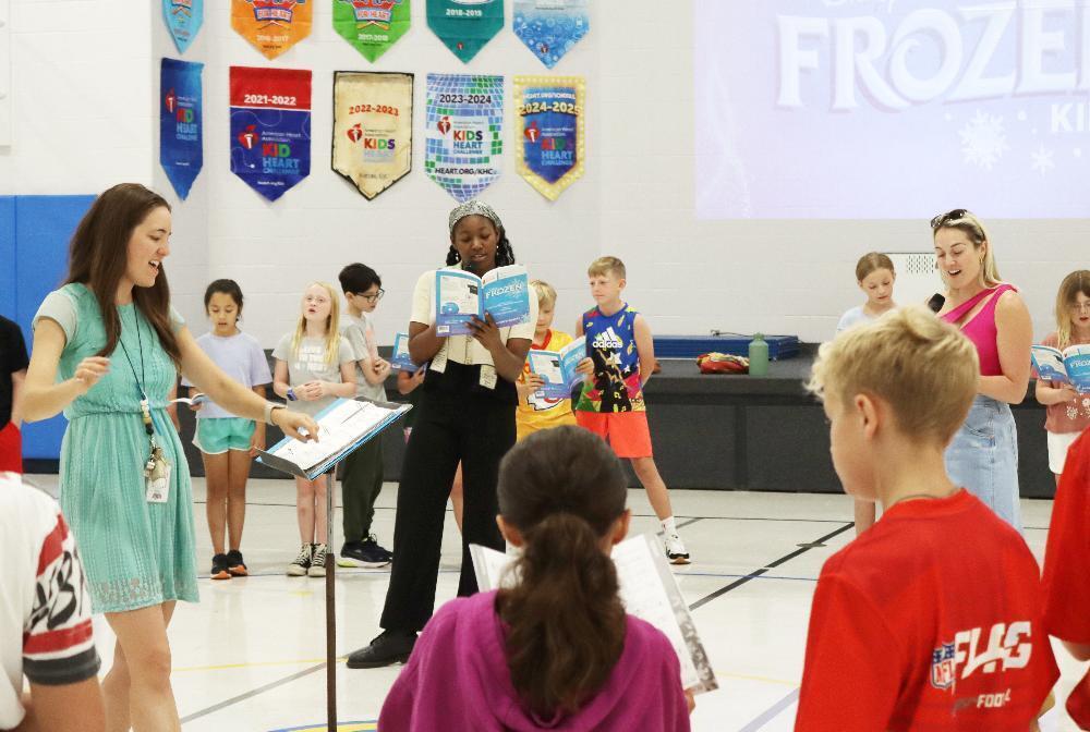 From left, Sheridan Elementary School music teacher Megan Stroup leads a song from the musical Frozen with student performers during a visit to the school.