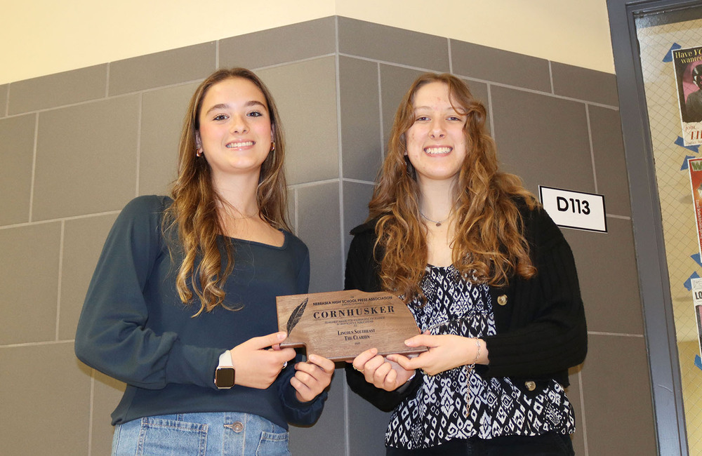 Lily and Myla hold an award that The Clarion newspaper staff received for excellence in journalism. They are serving as co-editors of the school newspaper this year.