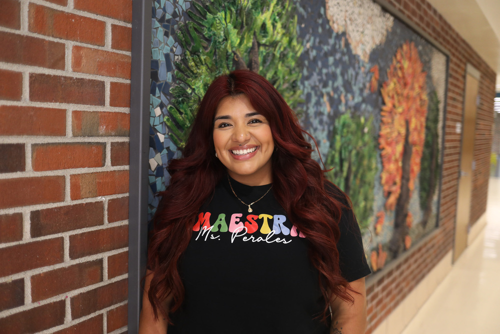 Claudia Perales-Garcia, teacher at Park Middle School standing in the hallway in front of the mural.