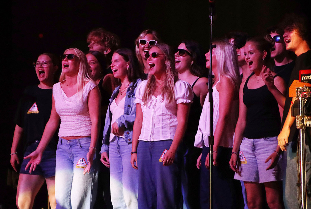 Southeast High School students sing to the Foreigner song "I Want to Know What Love Is" on stage of the Pinewood Bowl Theater. Thirteen members of Ars Nova are in the photo.