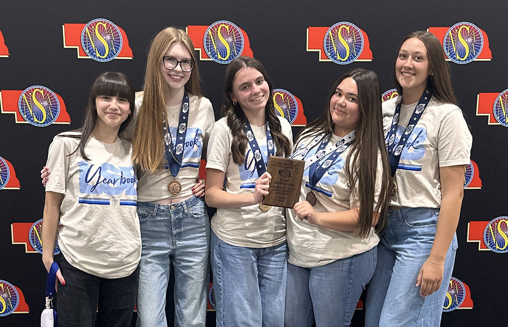 Five Standing Bear yearbook students stand in a row with their state championship plaque. The Grizzlies won the Class B Yearbook Theme Development contest.