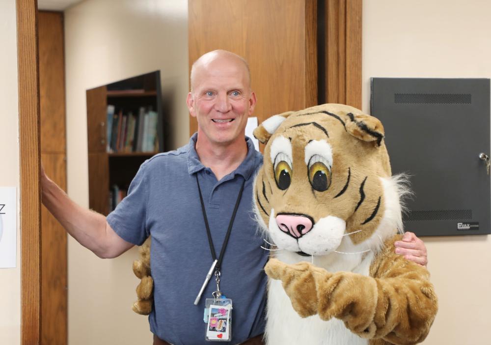 West Lincoln Principal Scott Schwartz smiles with the school mascot outside his office at the elementary school.
