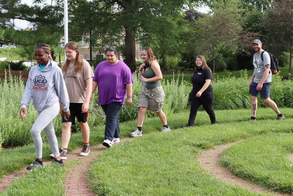 Students in a Lifetime Sports class walk in a line at Hamann Rose Garden.