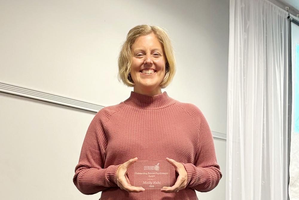 Molly Kuhl, a school psychologist at Lincoln Public Schools, smiles with a state award she received from the Nebraska Association of School Psychologists.