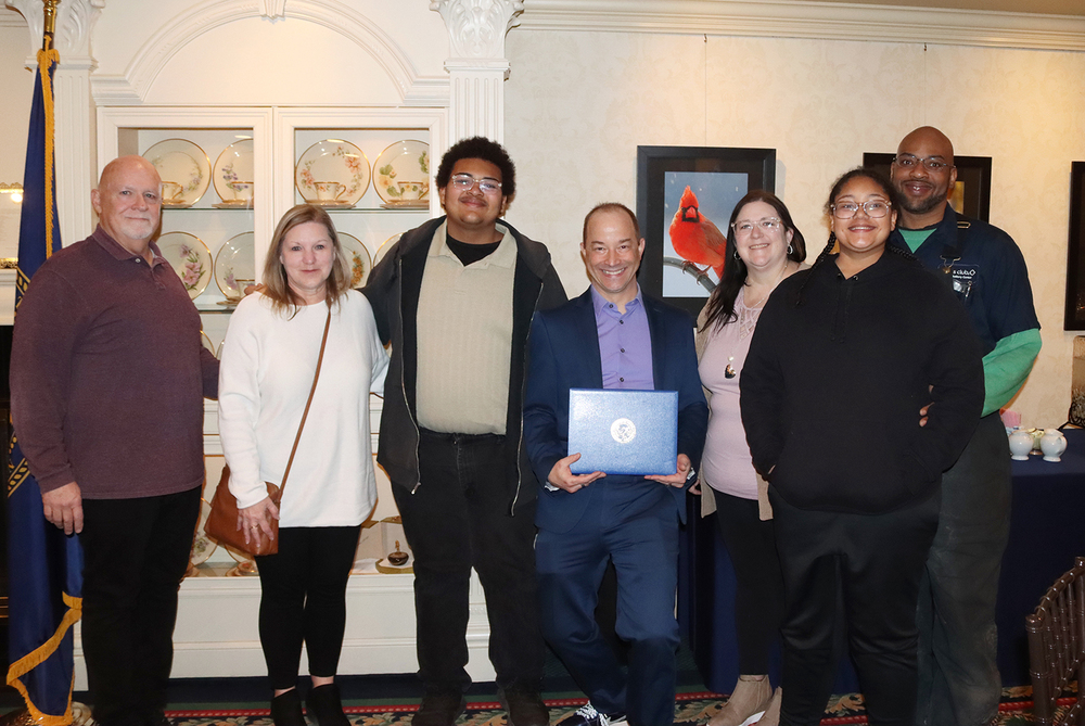 Irving Middle School student Izayah smiles with five family members and Irving teacher Brent Jung at the Thank You Teacher breakfast.