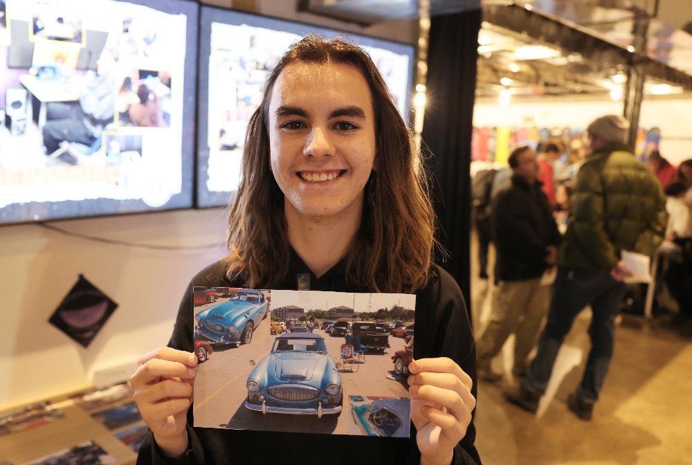Bay High Focus Program student Graham displays a picture of one of the cars he profiled for his senior passion project. The photo was taken at the Focus Program fair at Bay High School.