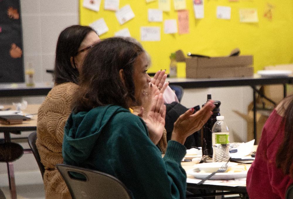 A Lincoln Public Schools student claps at a table in The Career Academy's main lobby. She is taking part in the CDA program launch celebration.