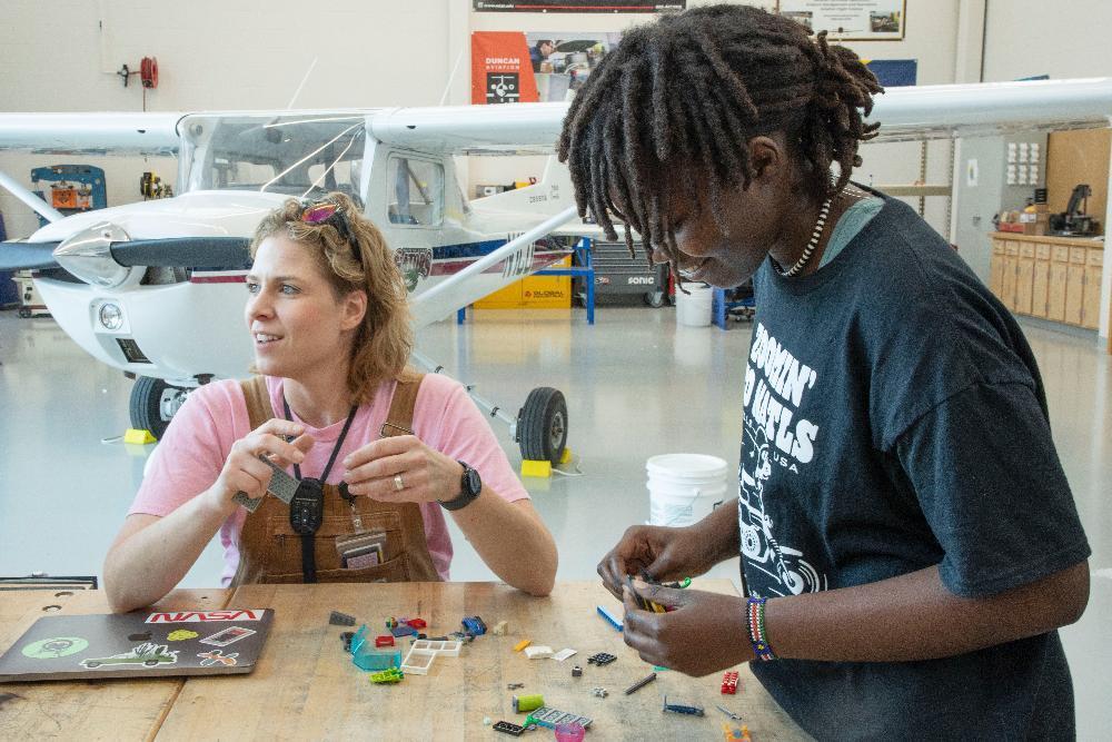 At left, LPS Aviation and Technical Education Focus Program teacher Amanda Woodward works on a Lego-robotics activity with North Star High School students in the program.